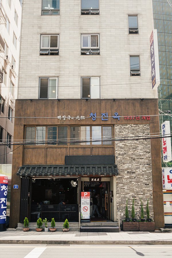 Multi-story storefront of Cheongjinok, signage reading "해장국의 元祖 청진옥 1937년 개업" ("The original hangover soup — Cheongjinok, opened 1937") above the entrance