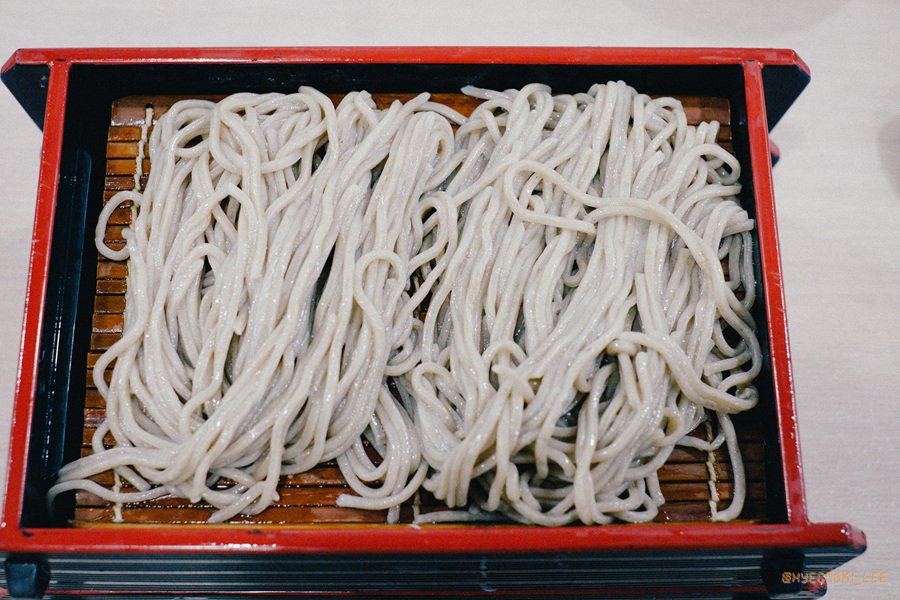 A lacquered box of cold buckwheat noodles, plain and unsauced, ready to be dipped