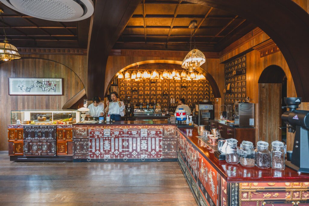 Interior view of the bar counter, made from a repurposed traditional medicine cabinet, with hanging pendant lights shaped like folded medicine packets