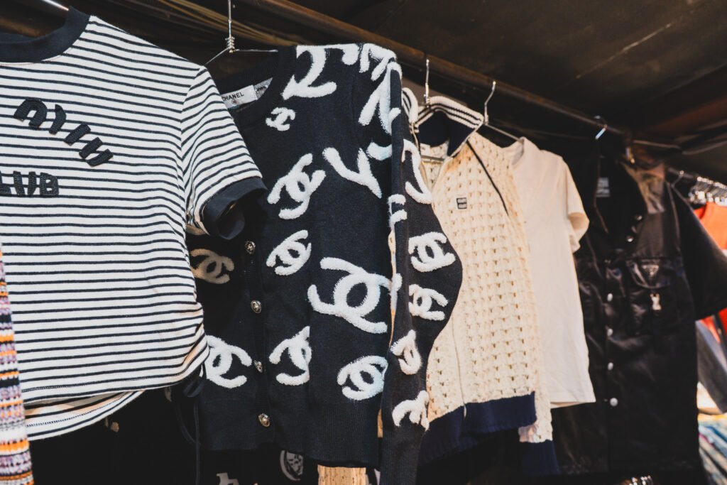 A Chanel monogram cardigan hanging on a rack among other vintage pieces at Dongmyo Flea Market