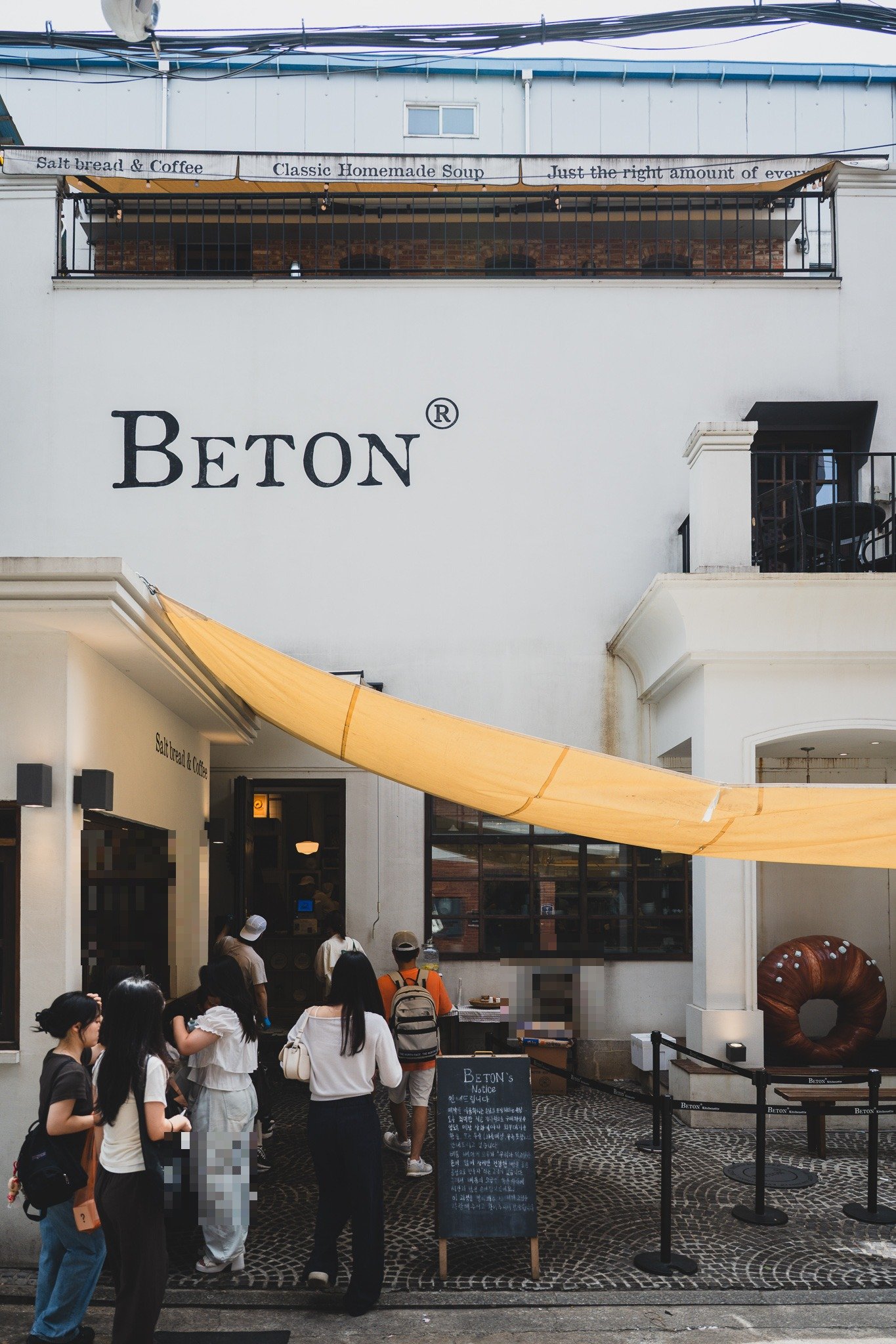 BETON's storefront in Seongsu, a white building with a yellow awning reading "Salt bread & Coffee" above a line of customers waiting outside