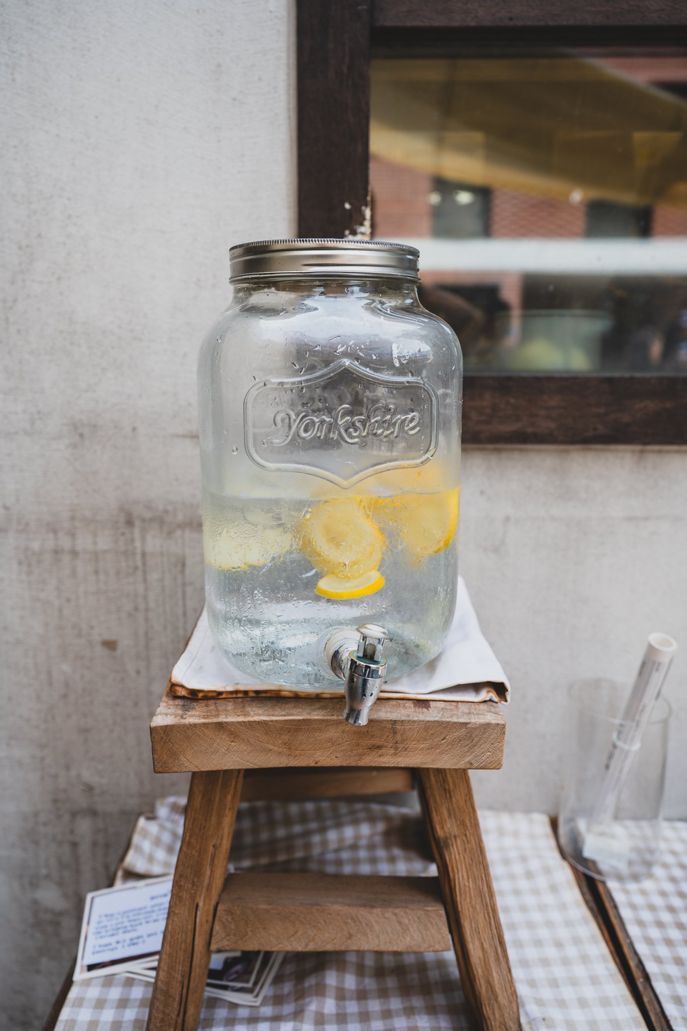 Lemon water dispenser set out on a table next to the queue outside BETON, provided free for people waiting in line