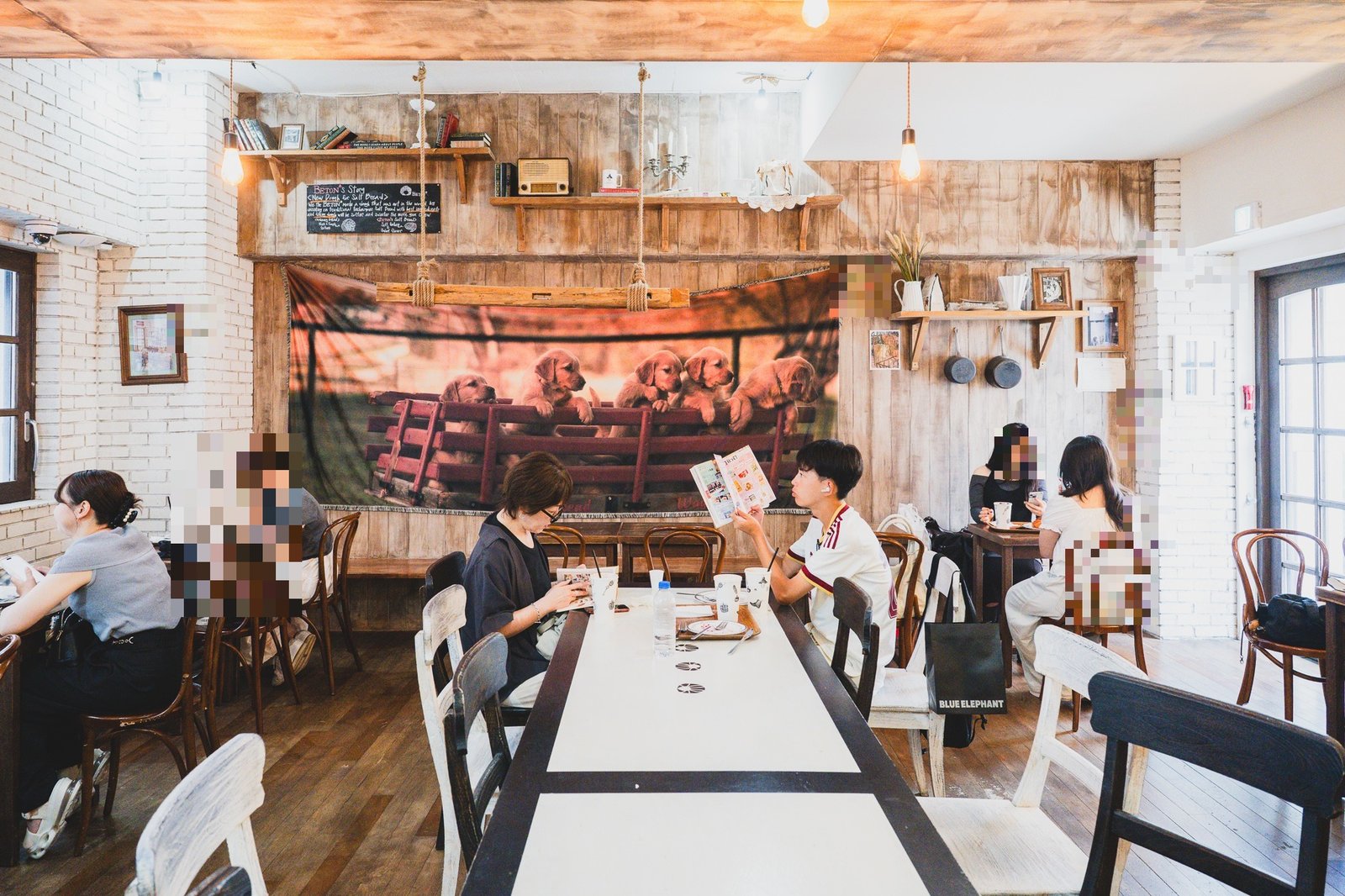 The upstairs seating area, a long communal table running down the center of the room beneath a large tapestry