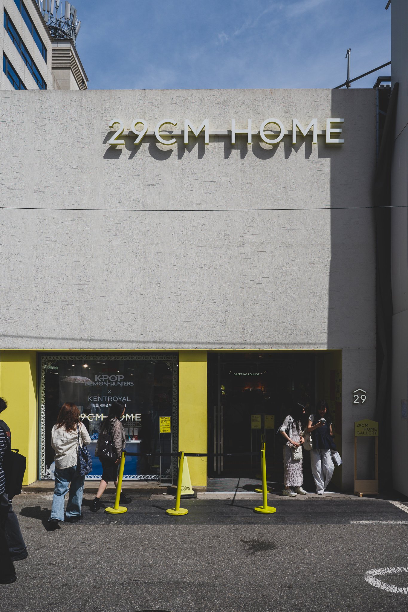 Storefront of 29CM HOME Seongsu with the Kentroyal x KPop Demon Hunters collaboration signage visible near the entrance, a yellow line marking the walking path rather than a queue