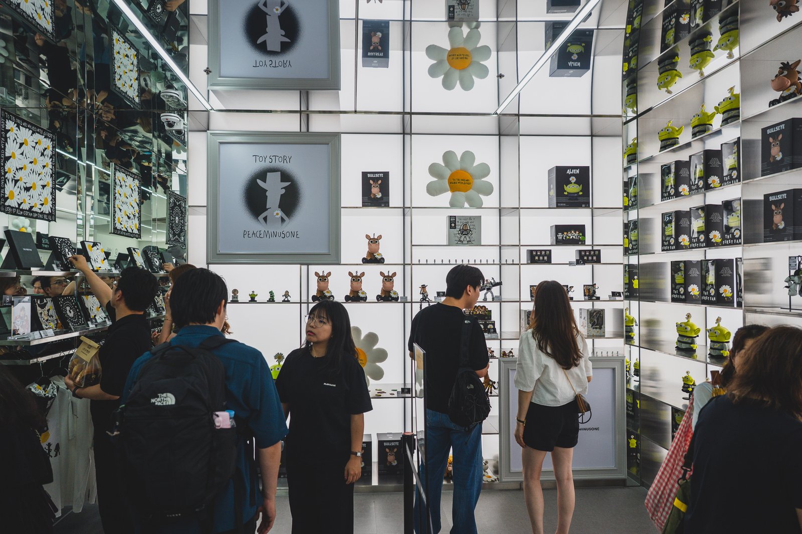 The 2nd floor "TOYSCAPE" display wall lined with merchandise, with visitors browsing the shelves
