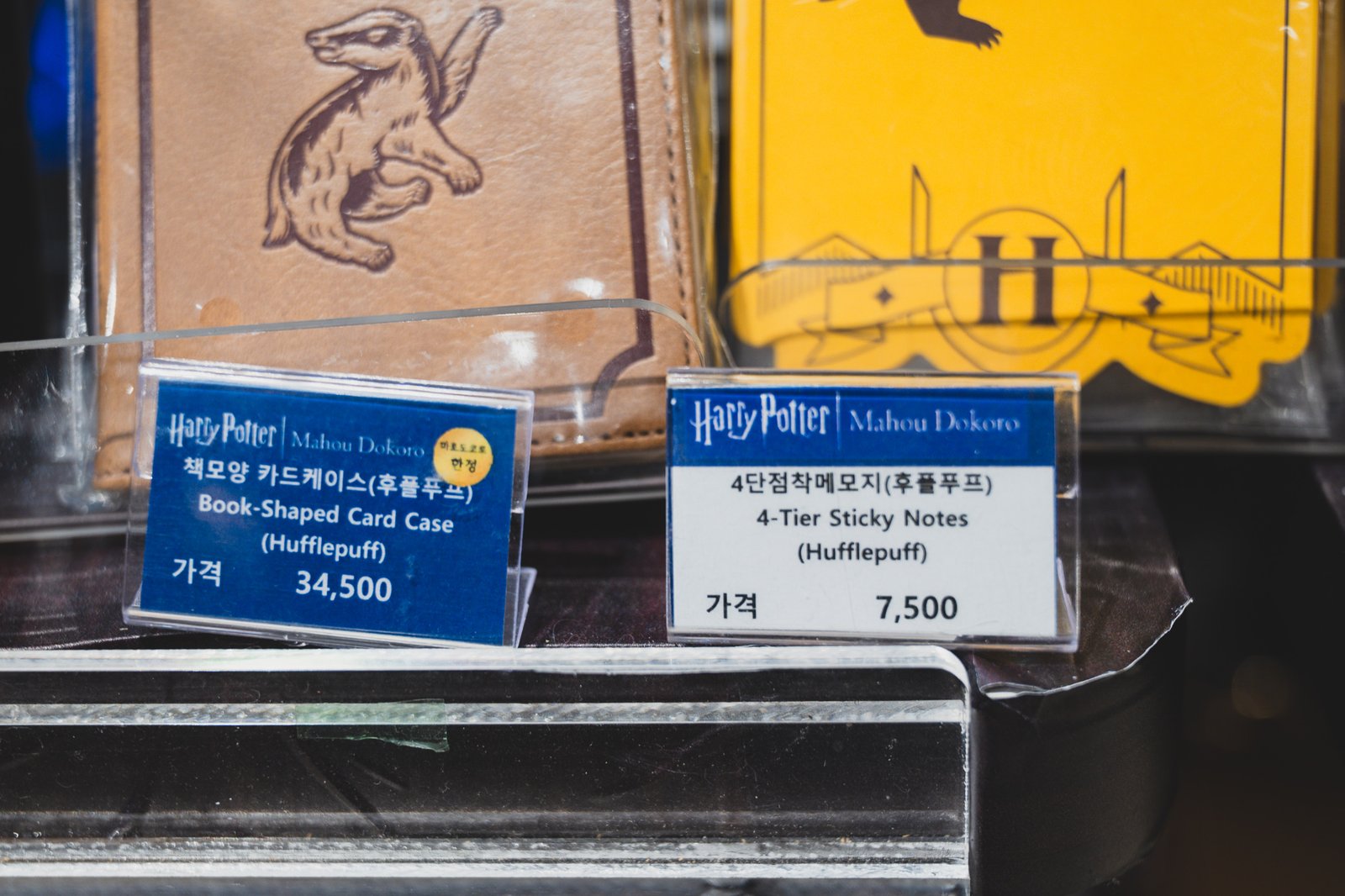 Price tags for Hufflepuff house merchandise: a book-shaped card case at ₩34,500 and a 4-tier sticky memo pad at ₩7,500