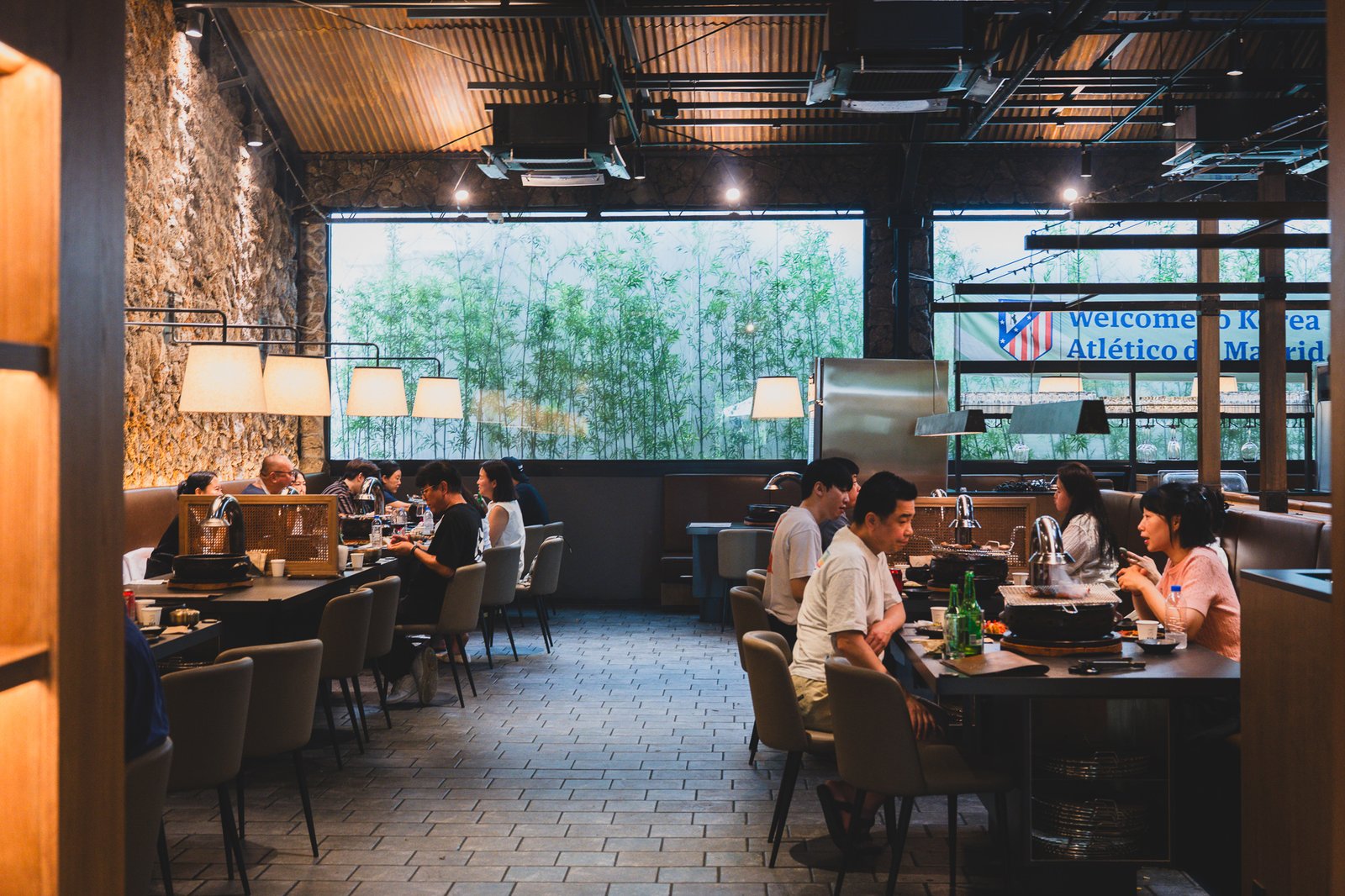 A dining hall interior with a "Welcome to Korea Atlético de Madrid" banner still hanging on the wall