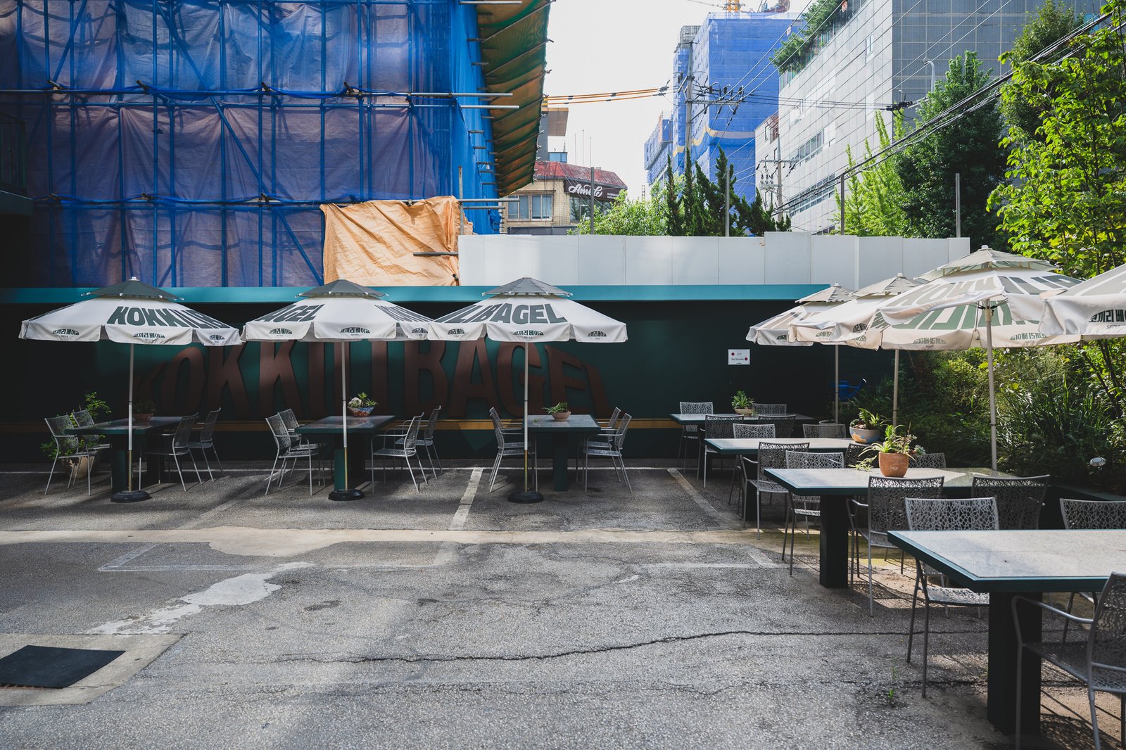 Side of the building showing a second outdoor terrace with umbrella seating and a large brand mural on the wall