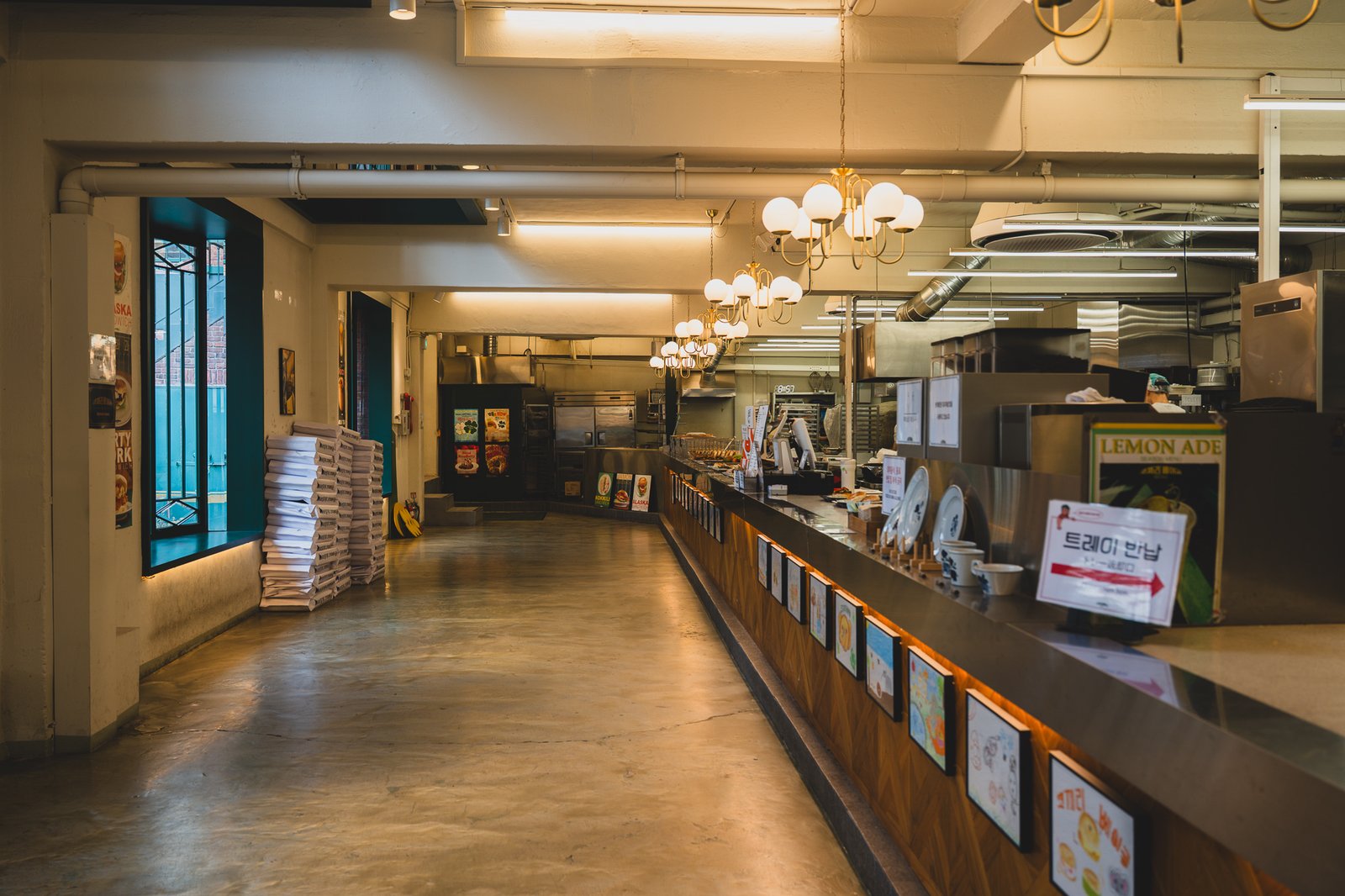 First floor ordering counter and wood-fired oven line, with tray-return signage and menu photos on the wall