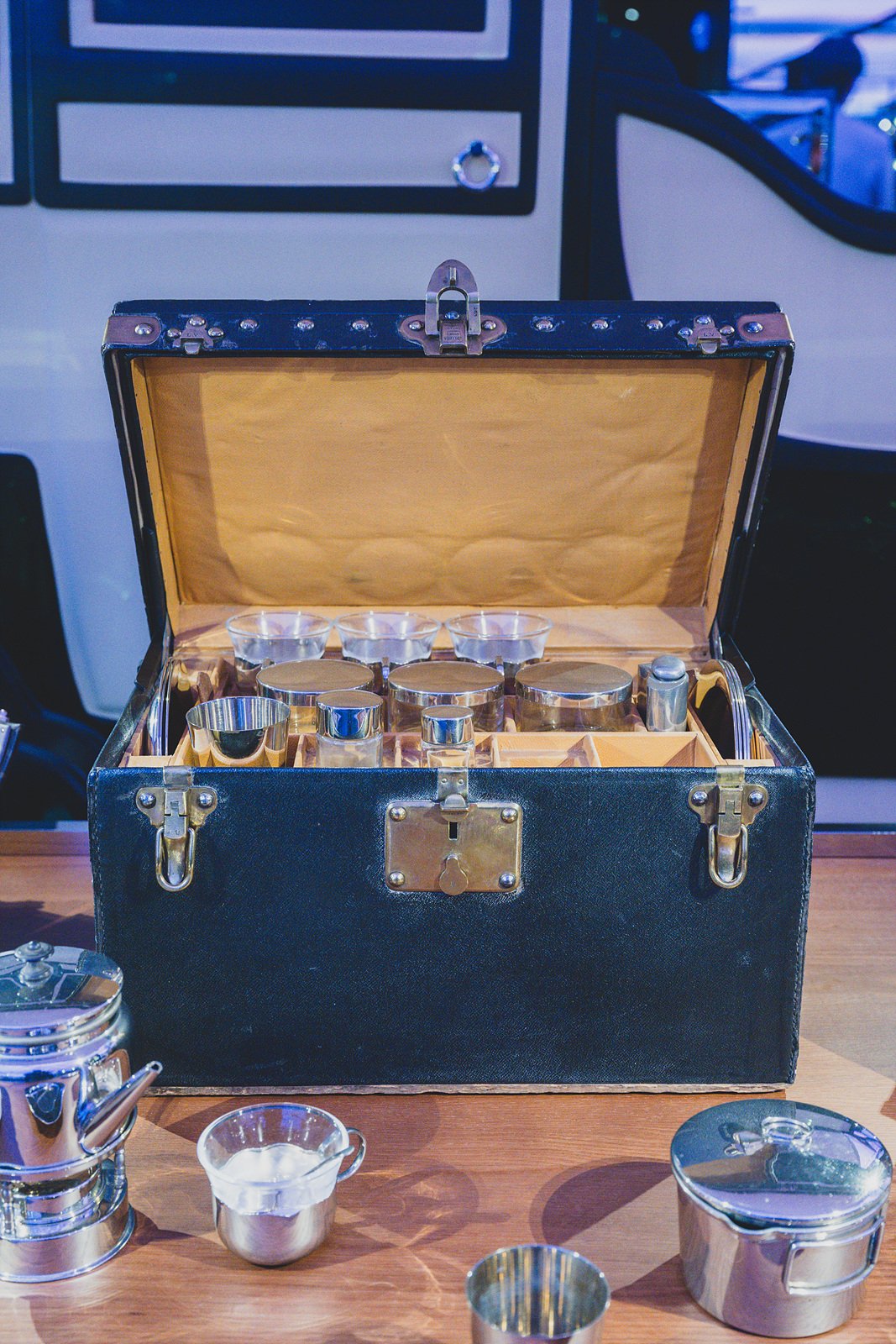 A vintage Louis Vuitton picnic trunk opened to reveal built-in silverware, cups, and containers