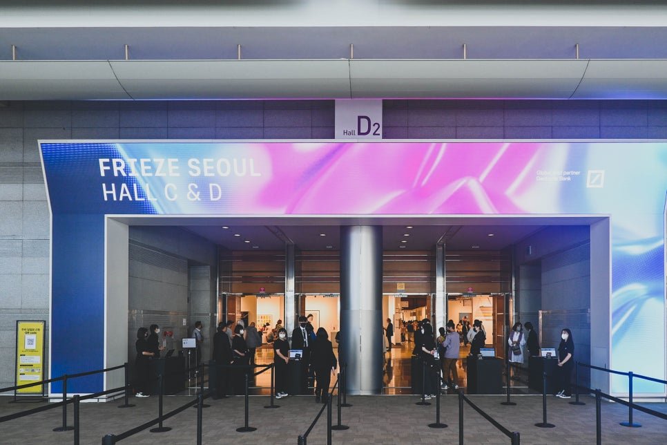 Entrance to Frieze Seoul, Hall C & D at COEX, with the Frieze Seoul banner overhead and visitors lining up at the check-in counters