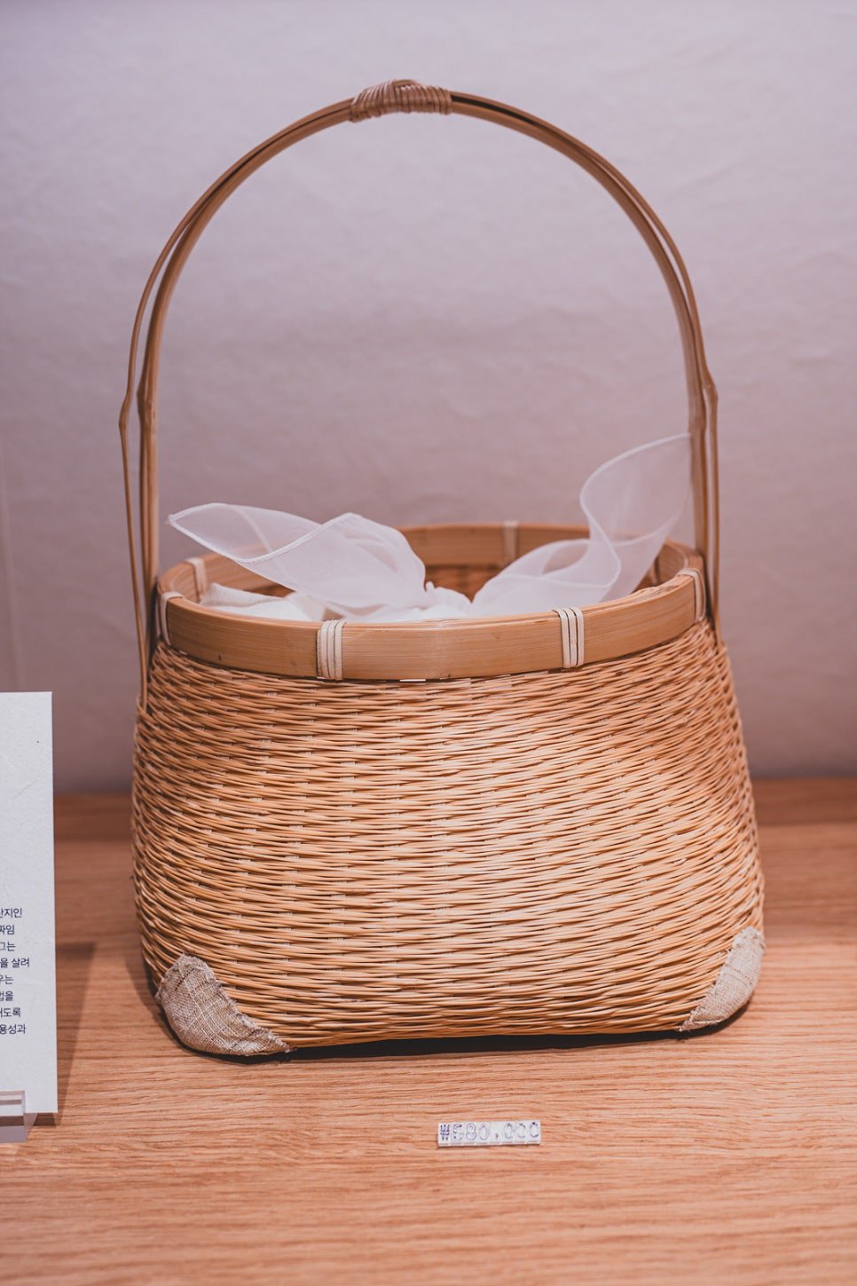 A hand-woven bamboo basket with a curved handle, priced at 580,000 won