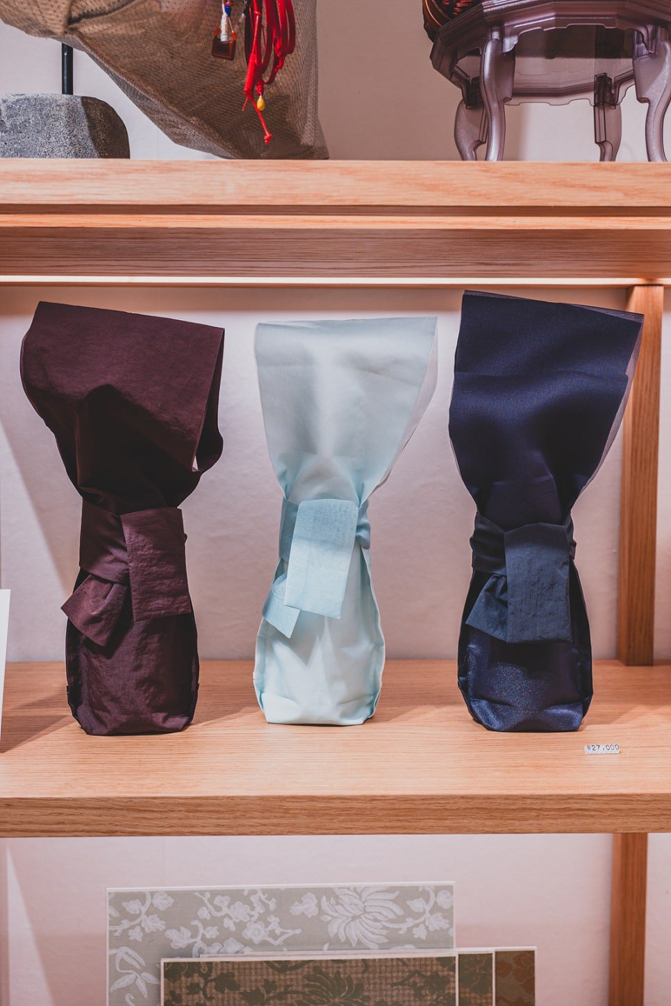 Three fabric wine bottle sleeves in burgundy, pale blue, and navy, priced at 27,000 won each