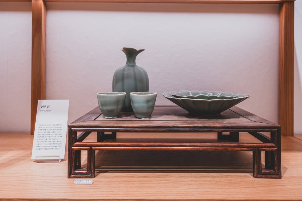 A celadon-glazed teapot, two cups, and a lotus-shaped dish by ceramicist Lee Eunbum