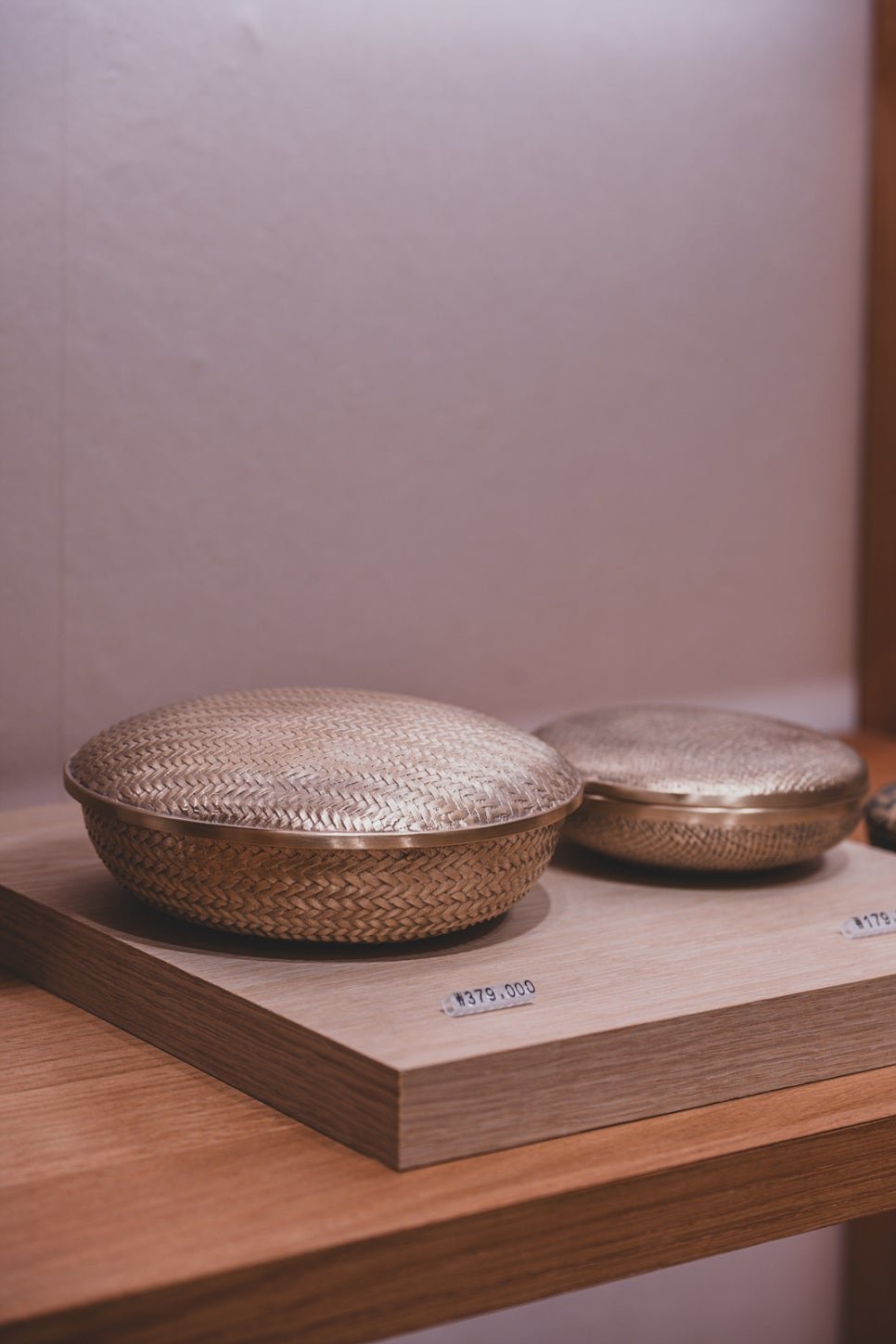 Two woven-pattern bronze lidded boxes from a 100-year-old Korean brassware tradition, priced around 275,000-379,000 won