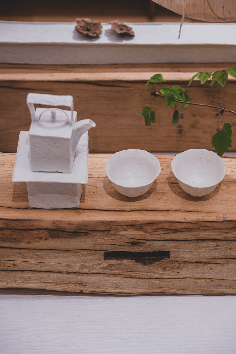 A minimalist white ceramic teapot and two cups with unusually thin rims, by artist Park Seong-geuk