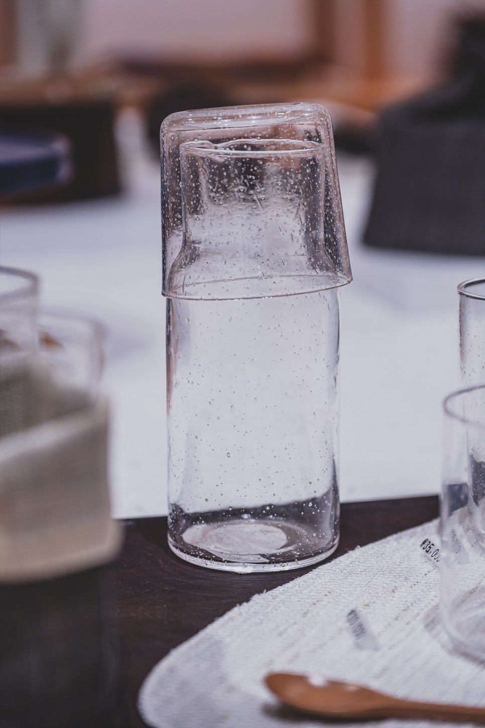 A hand-blown glass cup with visible bubble texture from the glassblowing process, part of the in-house Yunseul series