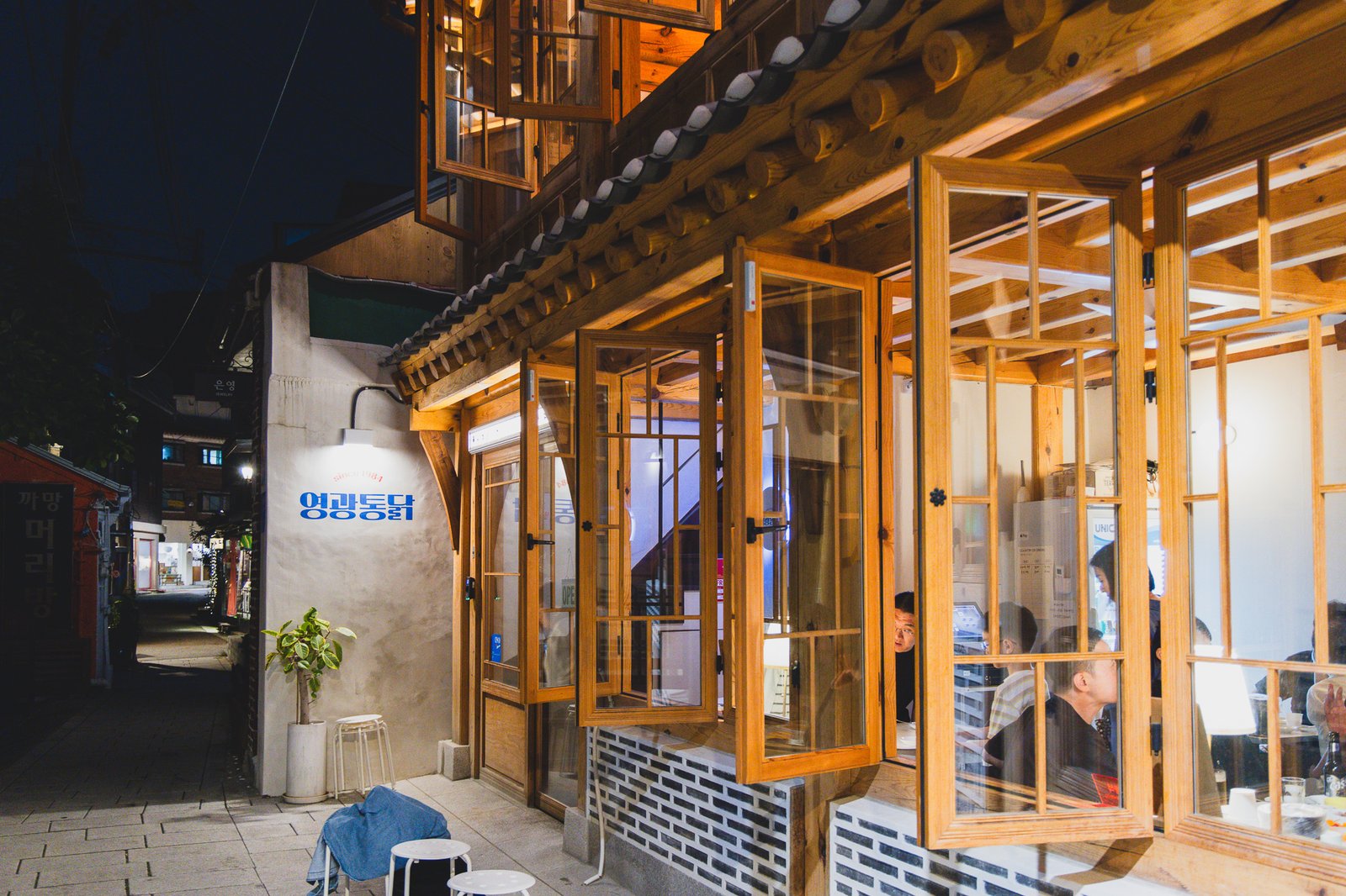 Nighttime exterior of Yeonggwang Tongdak 2, a two-story hanok-style building with wooden window frames and tiled roof