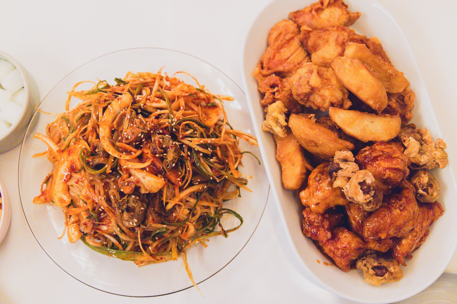 Golbaengi jjolmyeon plate next to the chicken plate