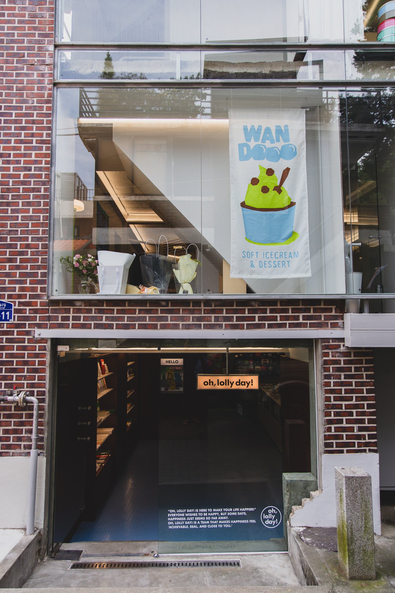 Storefront entrance with the "oh, lolly day!" lightbox sign and a banner for WAN DOO on the second floor