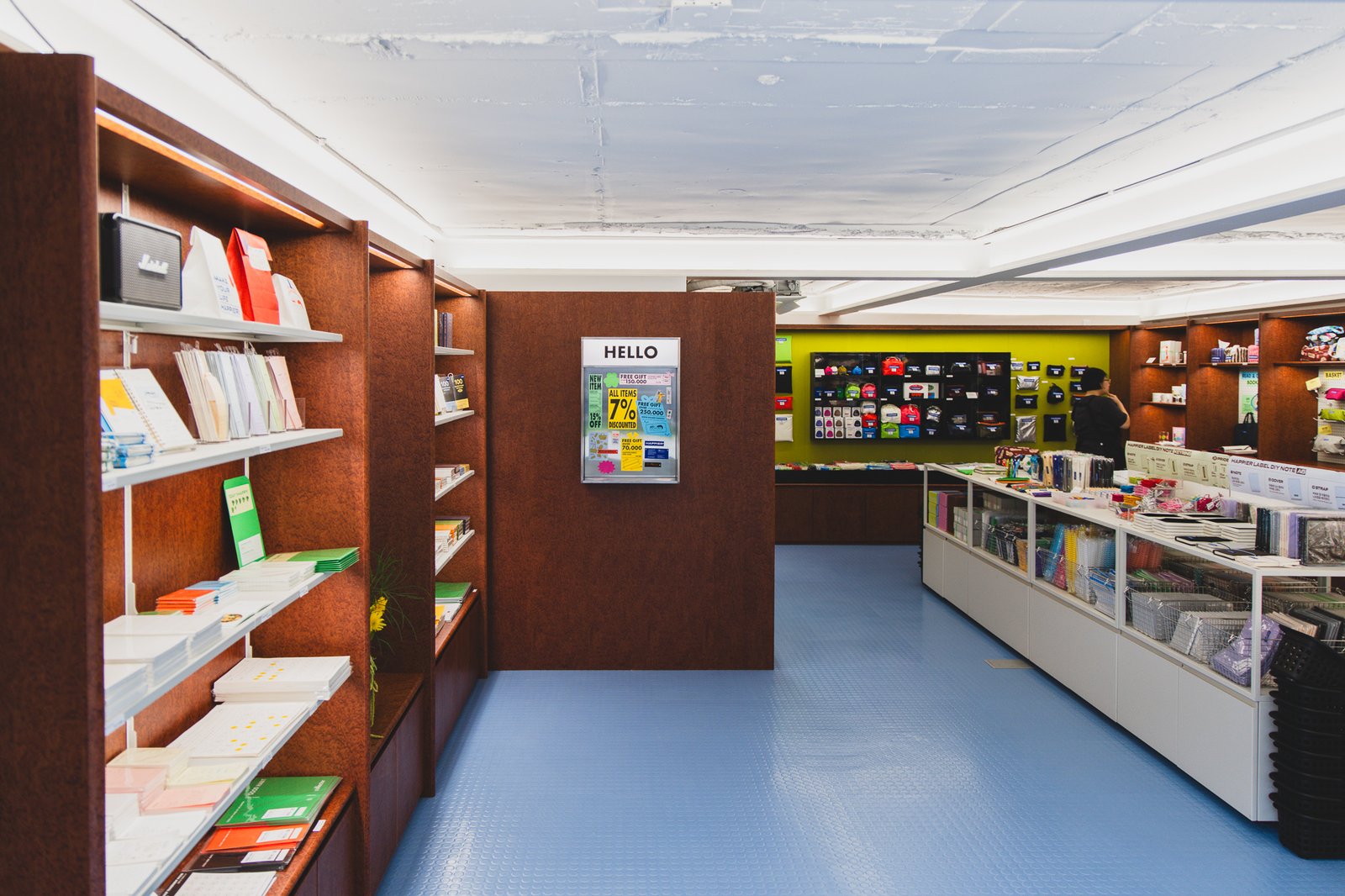 Interior of the basement-level shop, with wood shelving and a blue floor
