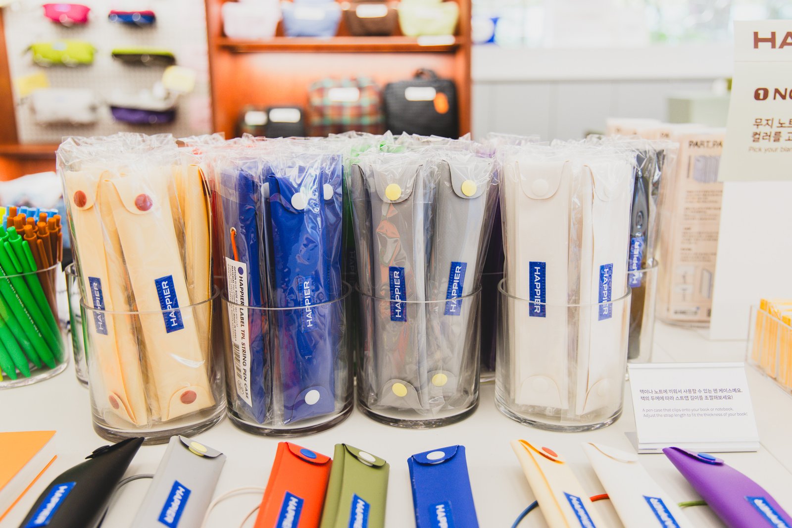 Rows of colored TPL string pen cases — ivory, blue, gray, white, and more