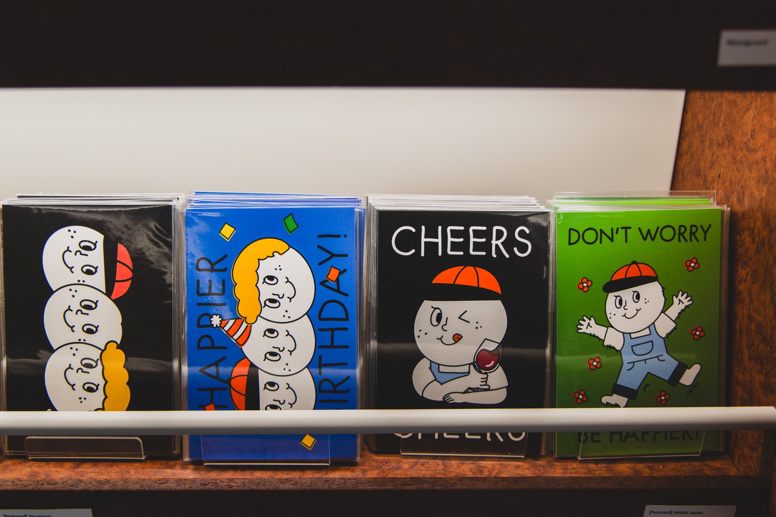 A series of cards featuring Oh, Lolly Day's round-faced character, with messages like "CHEERS" and "DON'T WORRY"