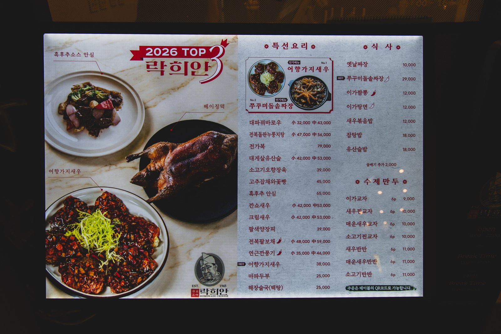 Rakhian's specialty menu board reading "2026 TOP 3" above photos of the restaurant's signature dishes, with a full Korean-language price list beside it