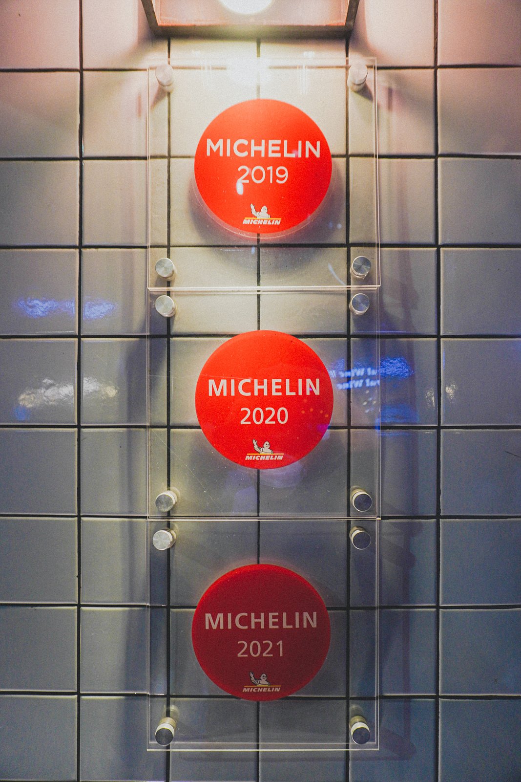 three Michelin Guide plaques mounted on the wall, reading "MICHELIN 2019," "MICHELIN 2020," and "MICHELIN 2021"