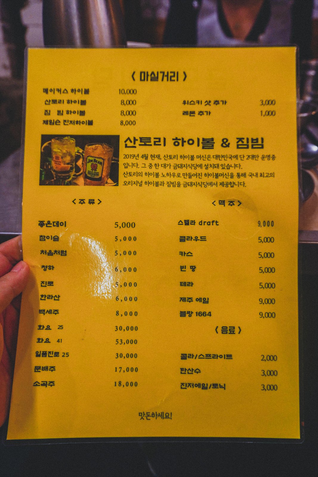 a drinks menu listing soju, beer, and highball prices, with a photo of two highball glasses