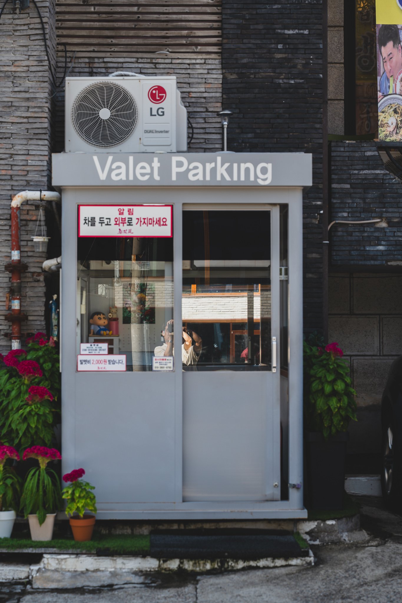 The valet parking booth outside Ihwawon, complete with an LG air conditioning unit and a small figurine visible through the window