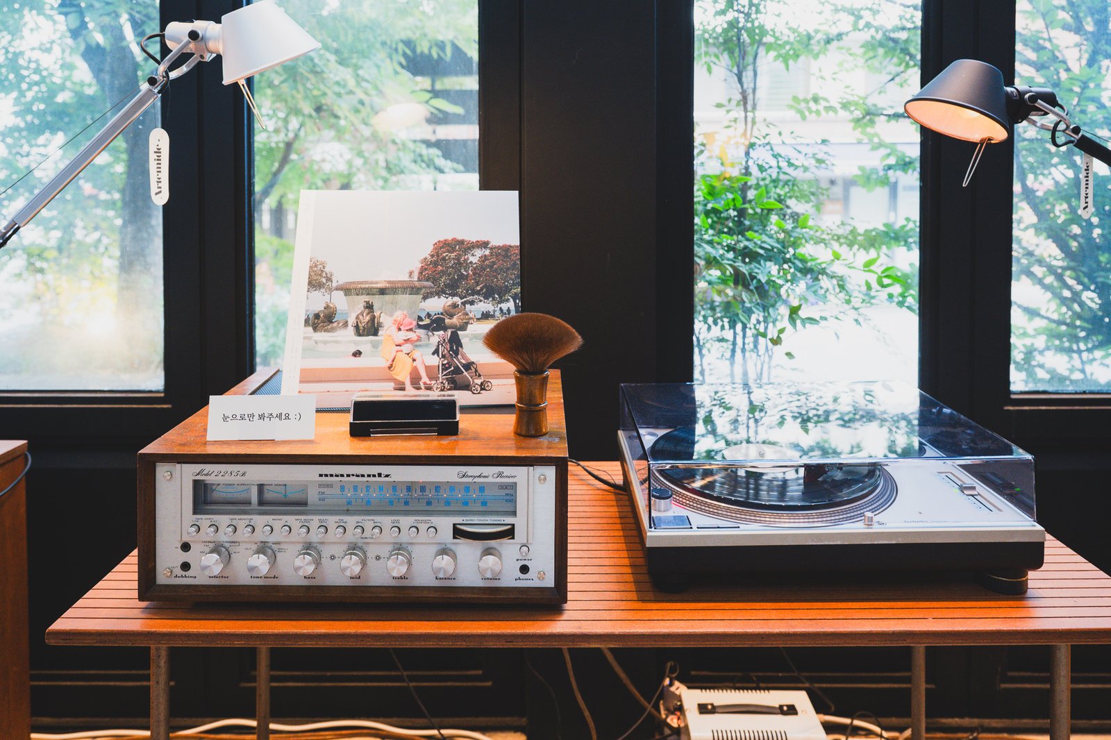 Close-up of the Marantz receiver's dial, a record brush, and album sleeves nearby