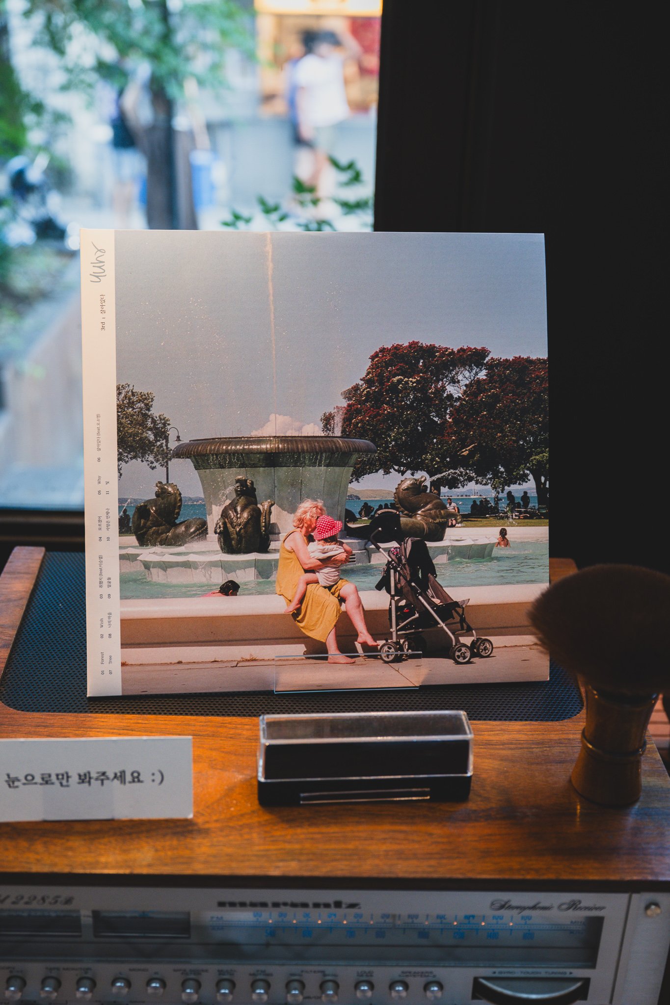 Album sleeve displayed upright next to a sign asking guests to look, not touch