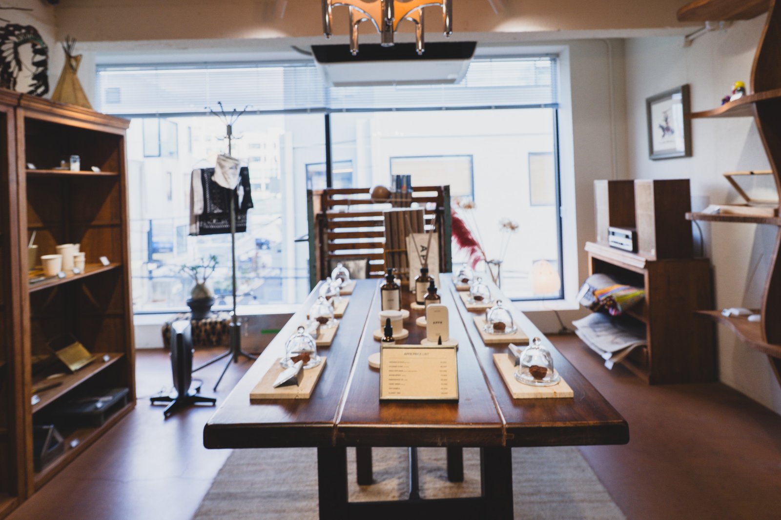 AFTERNOMAD's interior, showing the central APFR tasting table with glass display domes, wall shelving, and Native American-style decor on the far wall