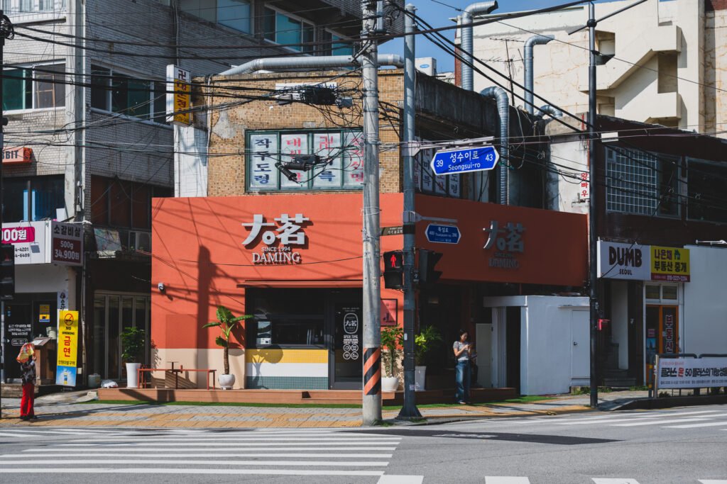 Corner storefront at the intersection of Seongsu-ro and Ttukseom-ro, Daming Seongsu's orange facade