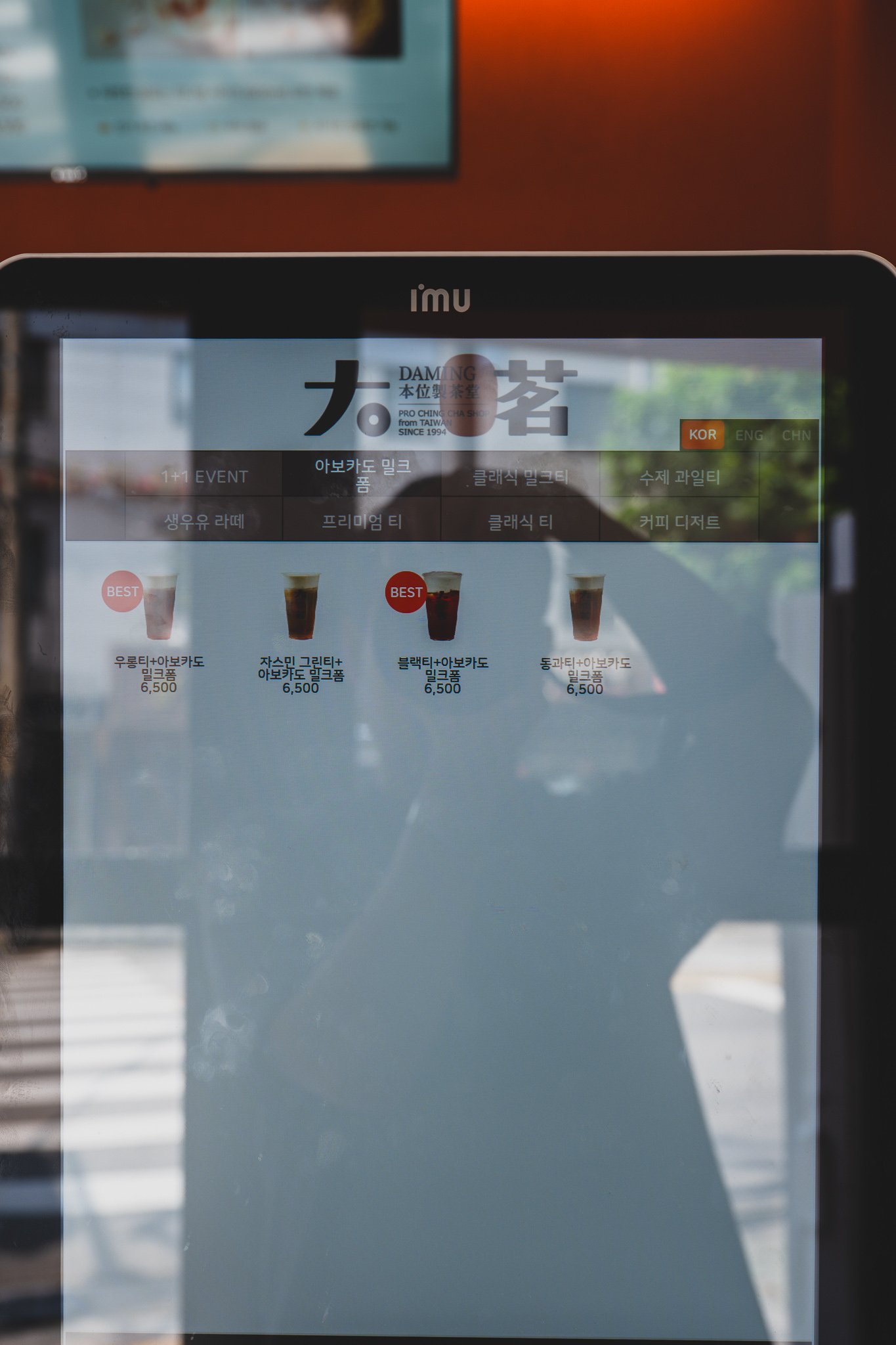 Self-order kiosk screen showing the Avocado Milk Foam and Classic Milk Tea categories