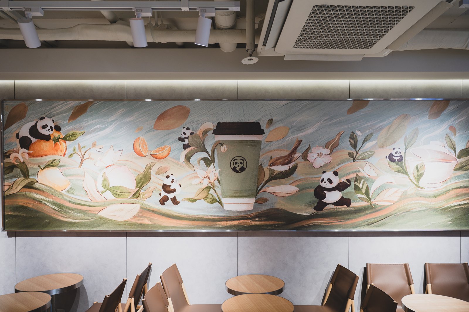 Large wall mural of pandas among persimmons, oranges, and magnolia flowers