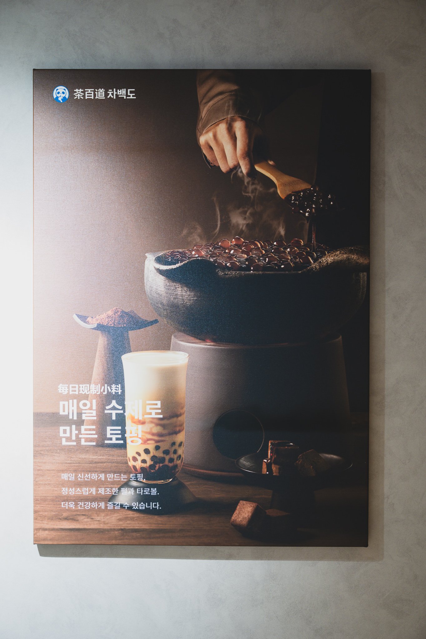 Poster titled "Handmade toppings, made fresh daily," showing pearls and taro balls being cooked in-store