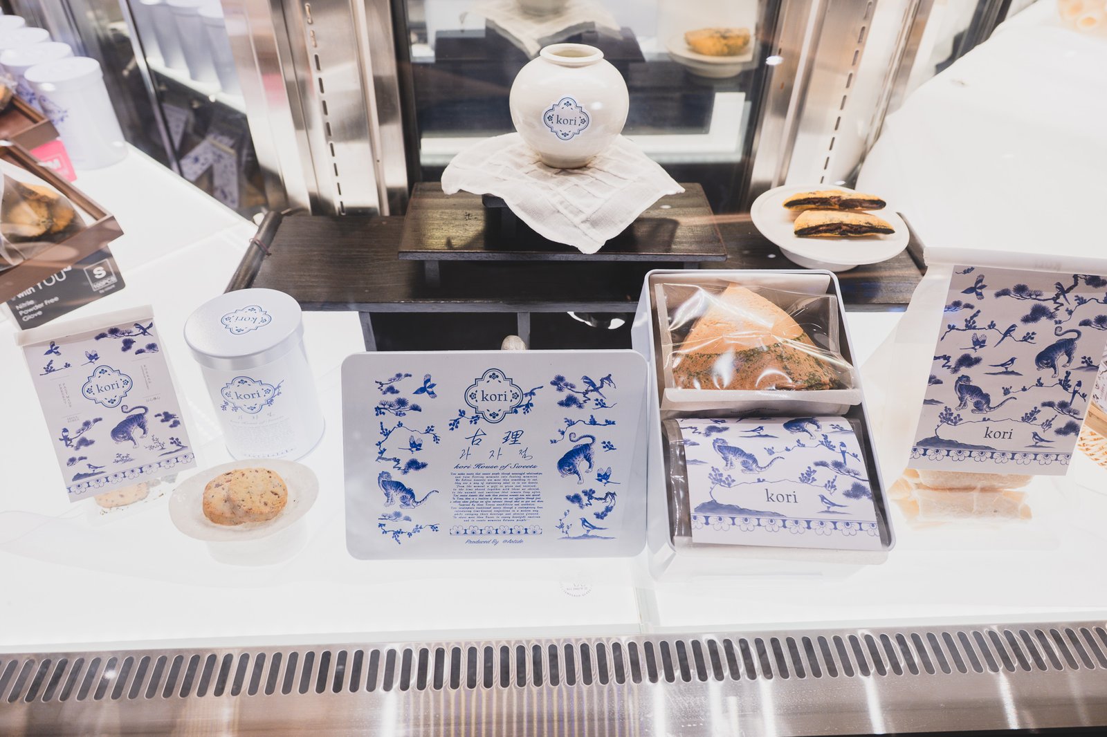 Display case with baked rice cakes, cookies, and gift-box crackers arranged together