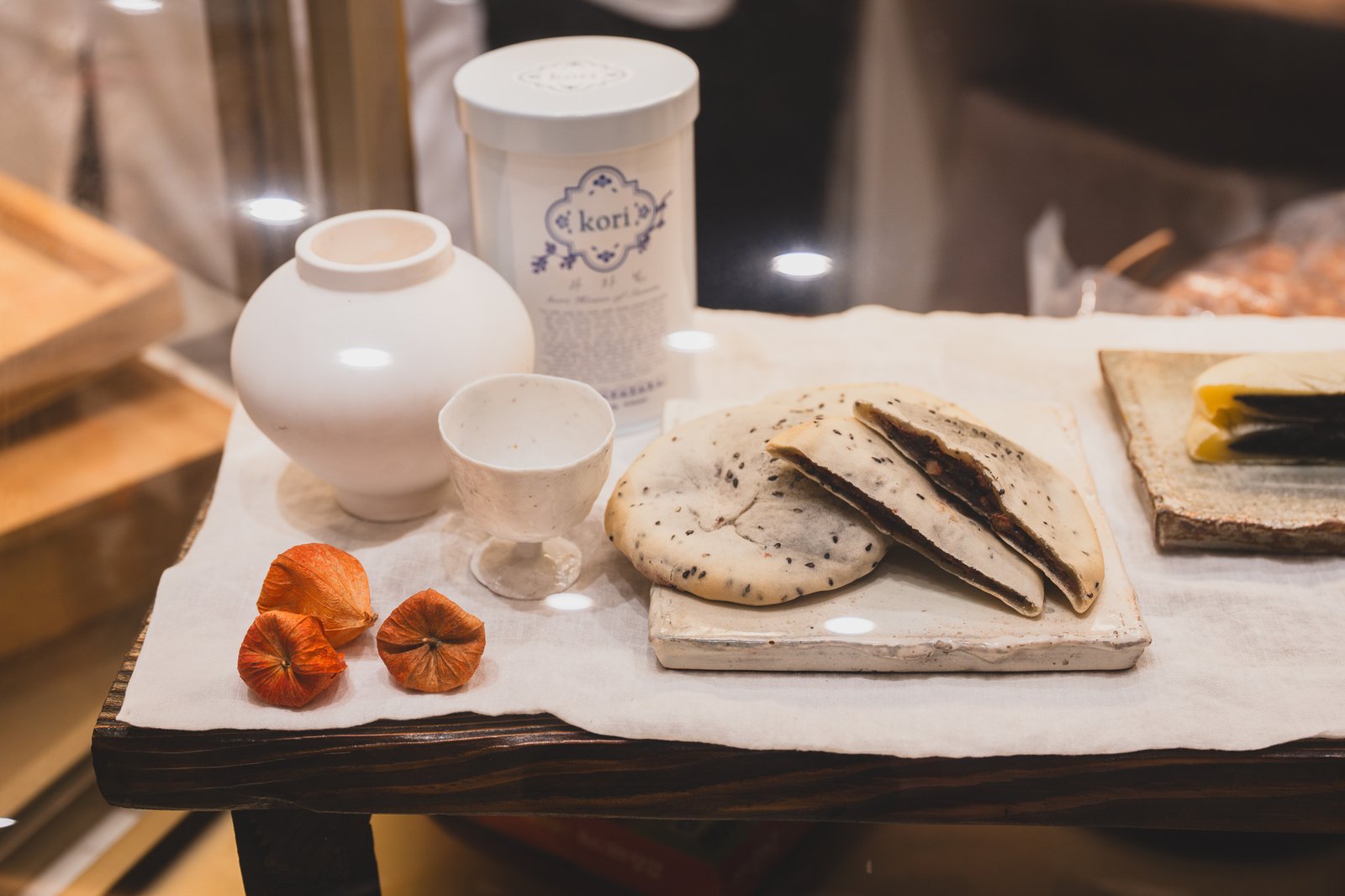 Styled shot of the finished rice cake next to the porcelain jar and kori tin case