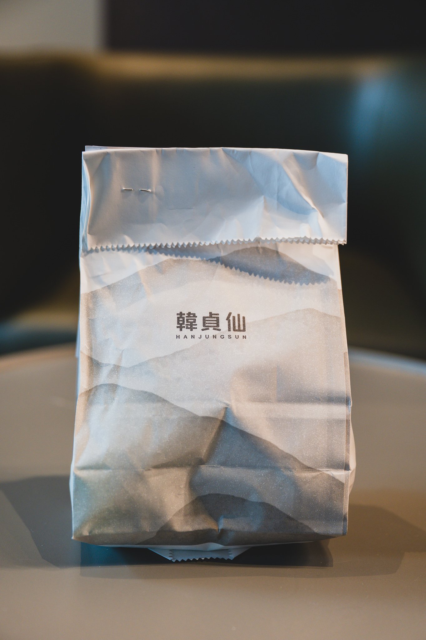 Hanjungsun's paper gift bag printed with a muted mountain-range graphic in traditional hanji-paper tones