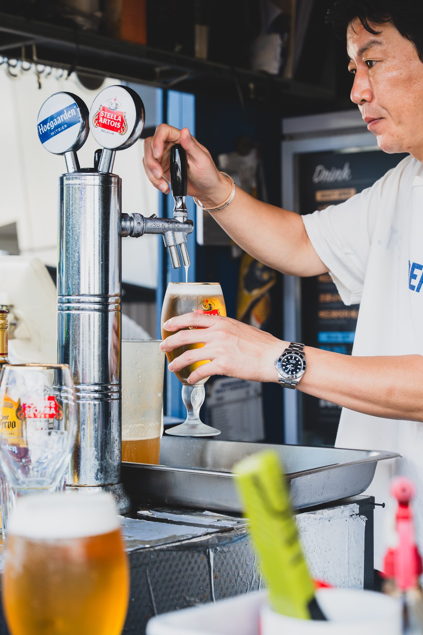 Bartender pouring a Stella Artois draft with visible attention to technique