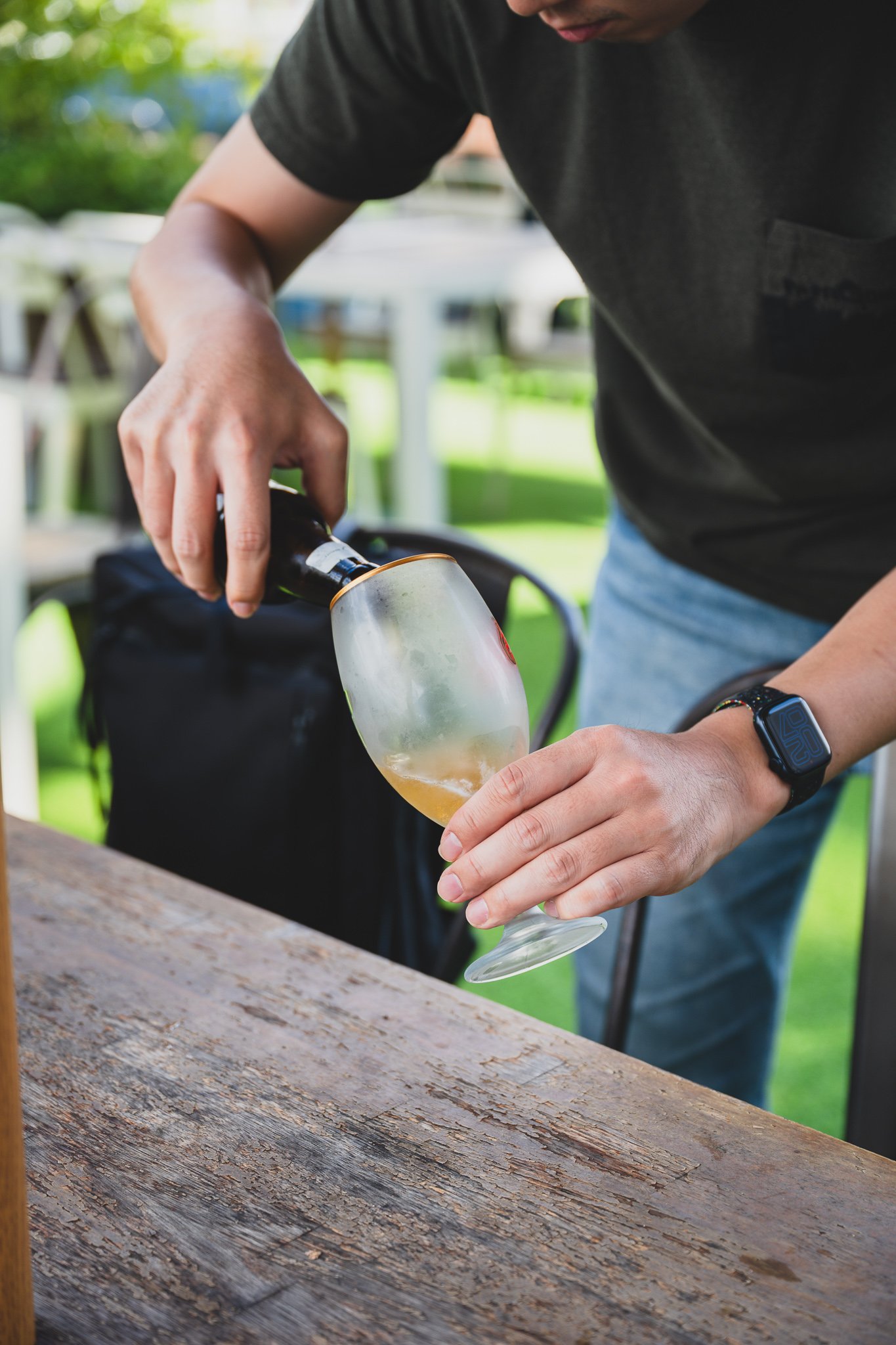 Hoegaarden being poured into a glass, the cloudy wheat beer color visible