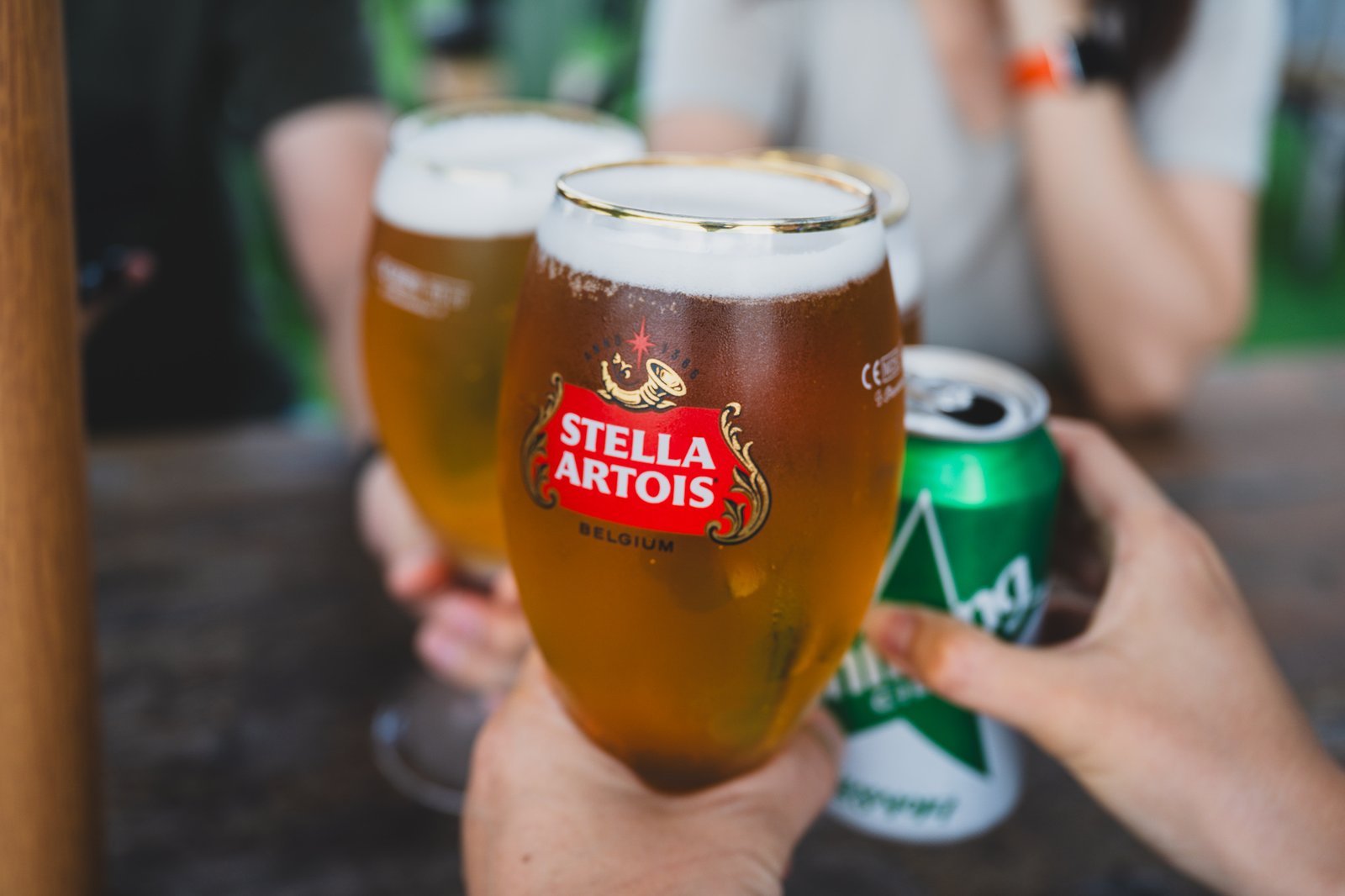 Group toast with Stella Artois glasses and a non-alcoholic can