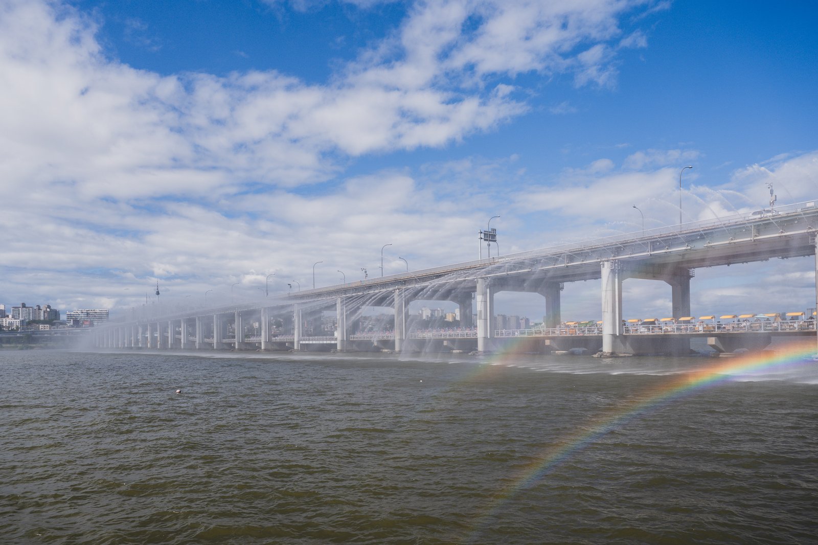 Rainbow forming under Banpo Bridge as sunlight hits the fountain spray