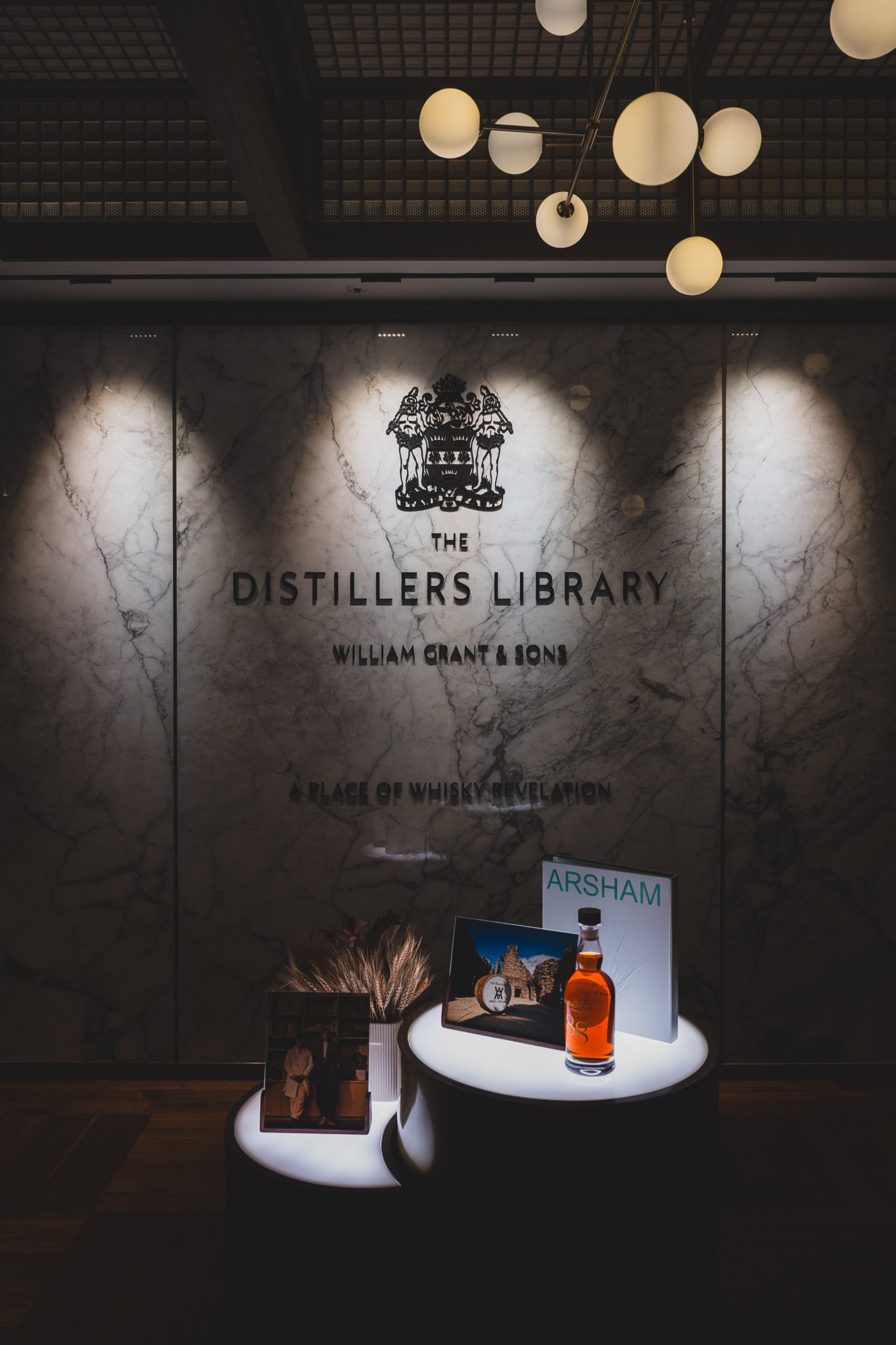 The Balvenie 88-year-old, a Daniel Arsham collaboration bottle, displayed beneath a marble wall logo