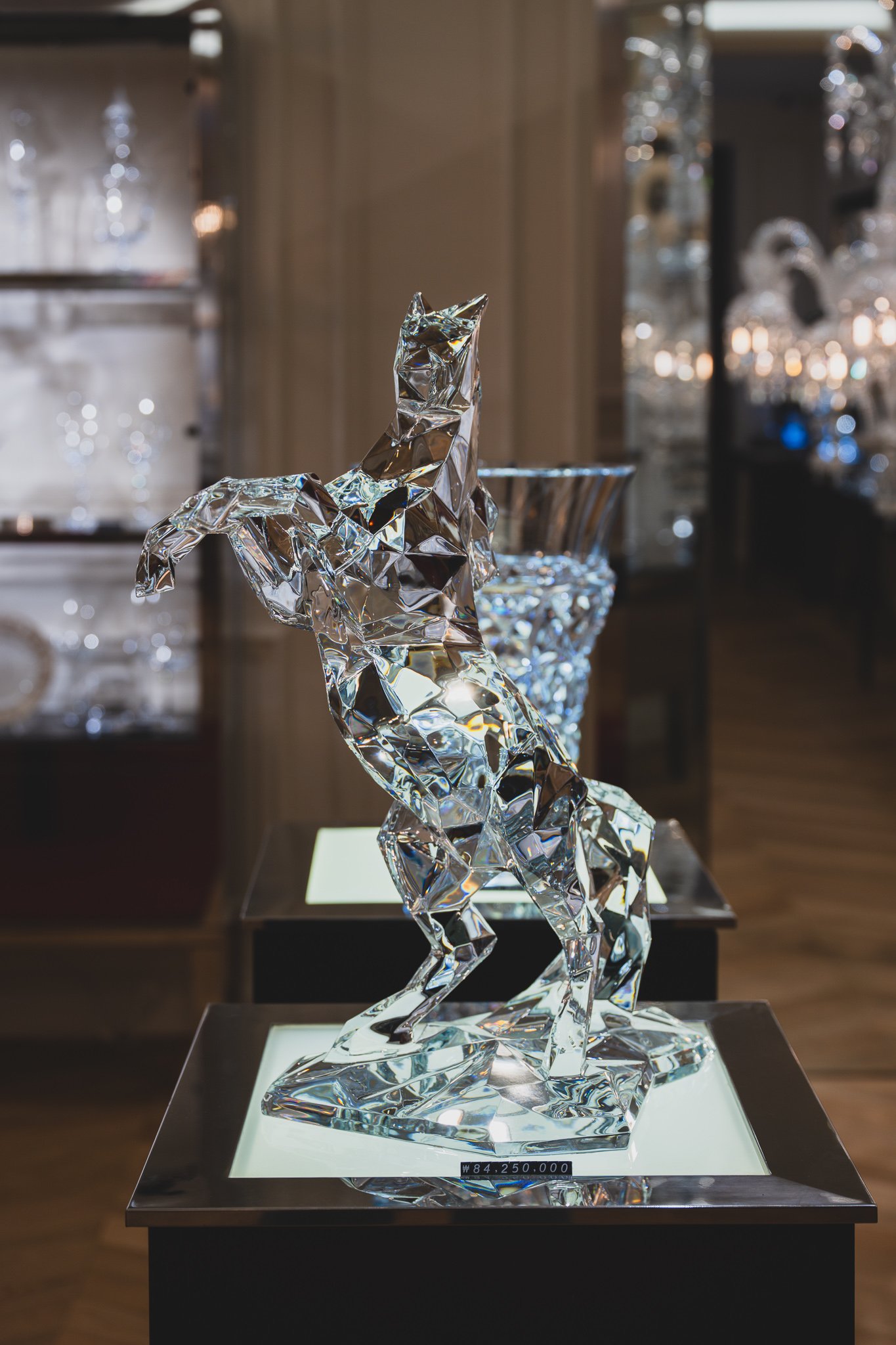 A crystal sculpture of a horse rearing on its hind legs, displayed on a pedestal