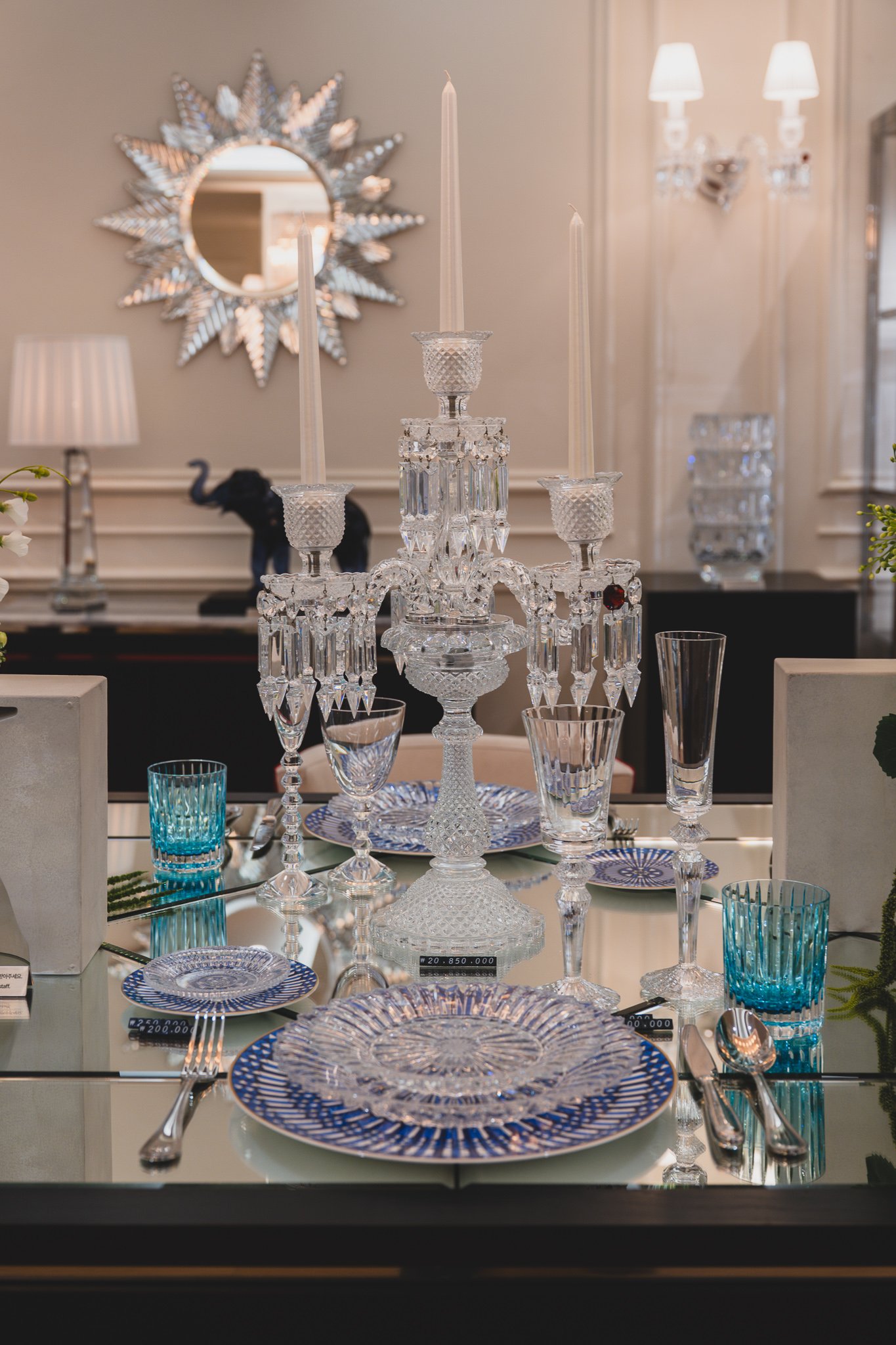 A dining table set with blue-and-white crystal tableware, a candelabra as the centerpiece