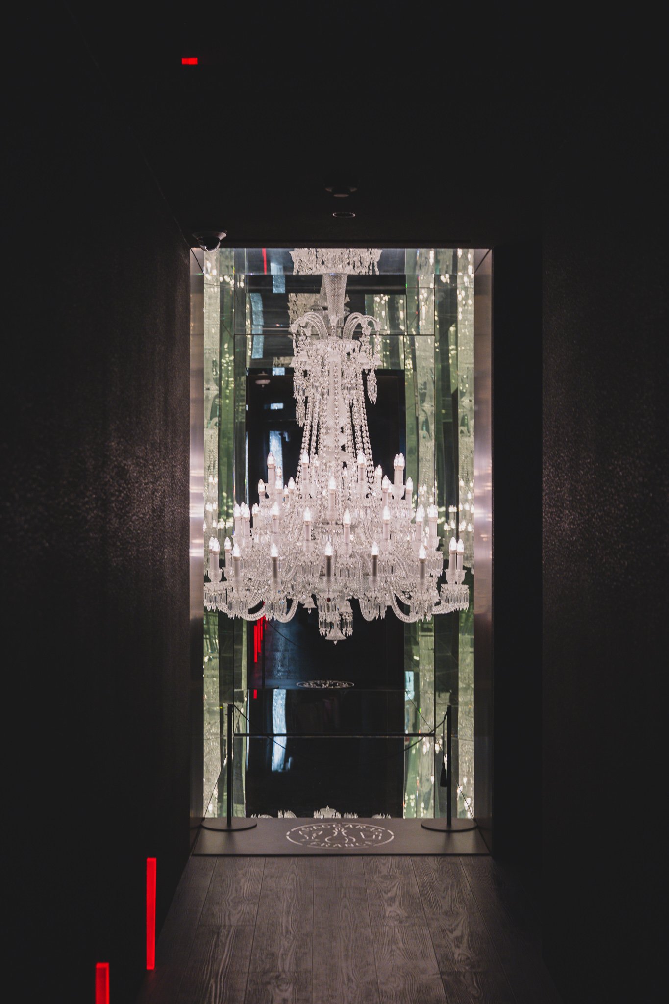 A narrow, mirror-lined staircase corridor leading up to Baccarat Bar Seoul on the second floor