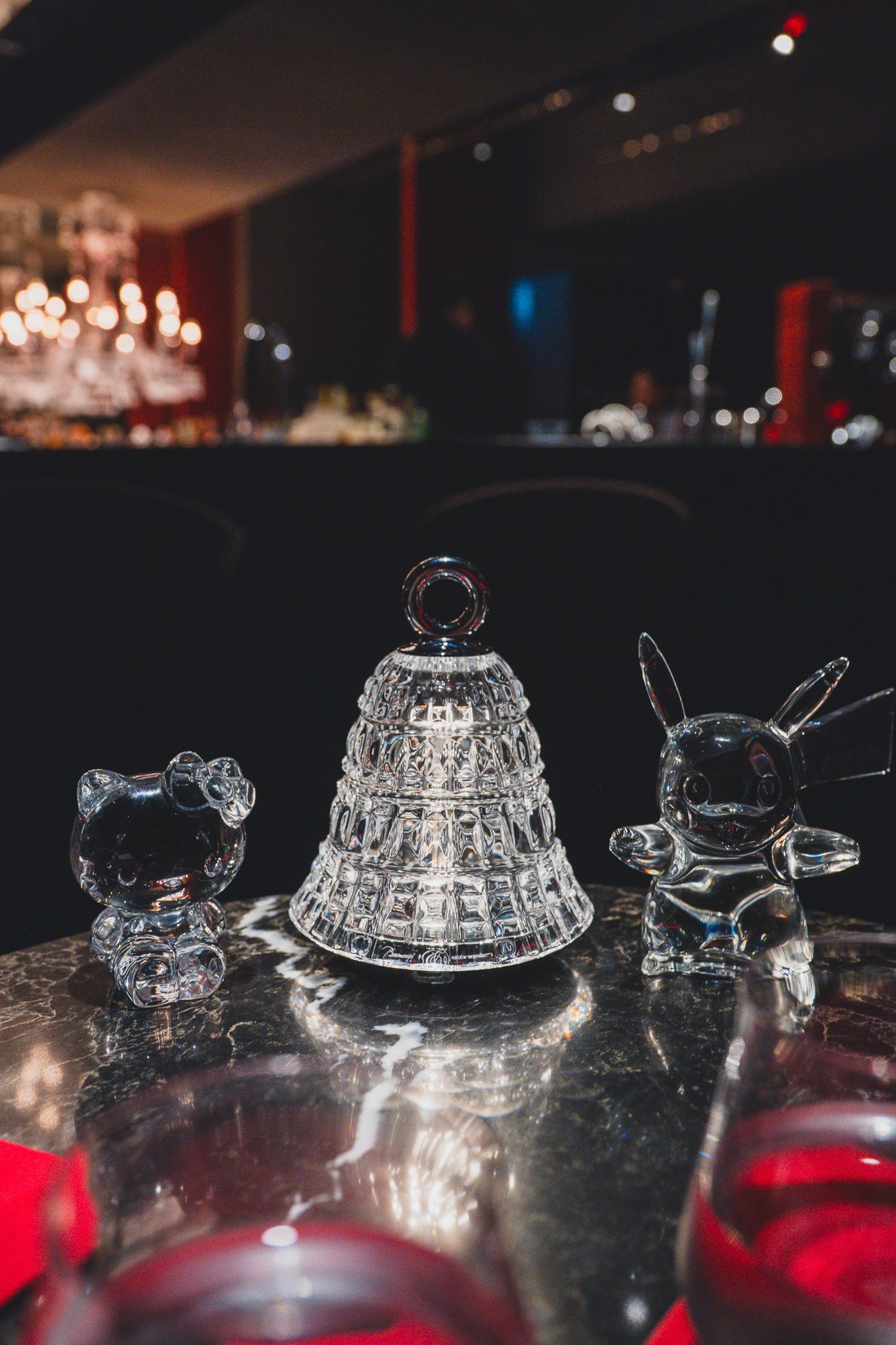 Crystal figurines of Hello Kitty and Pikachu lined up on the bar counter
